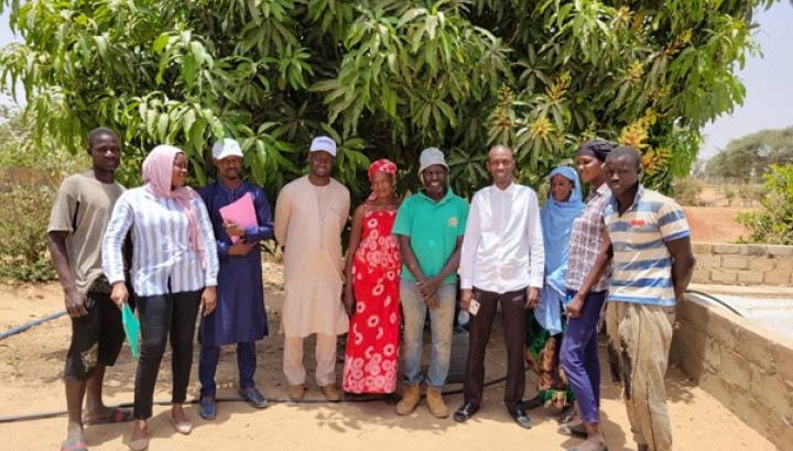 Image of beneficiaries standing in front of trees