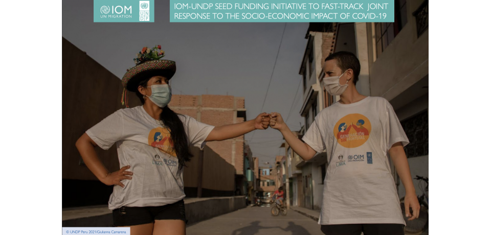 An image of two people wearing face masks and bumping fists
