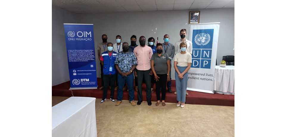 11 people standing next to the IOM and UNDP Mozambique banners