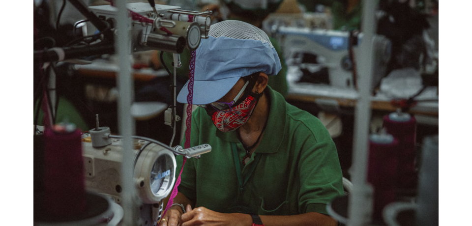 A factory employee working on a sewing machine