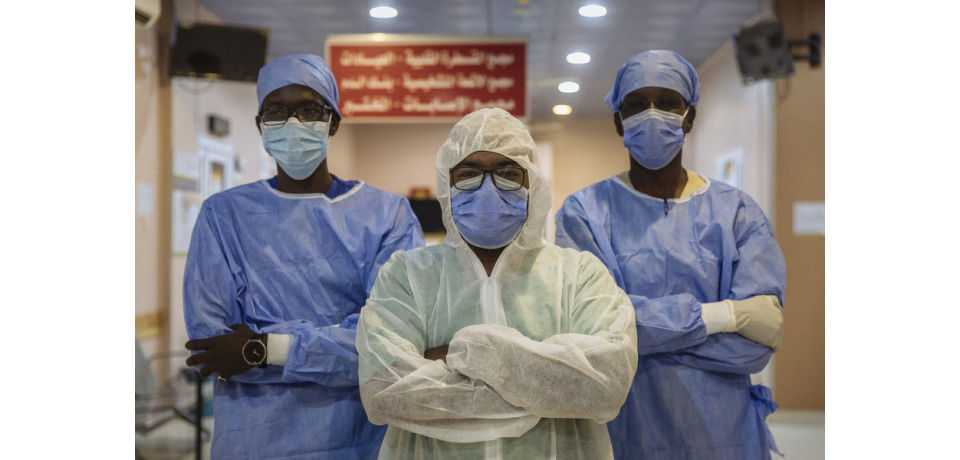 Three healthcare workers fighting the COVID-19 pandemic looking directly to the camera