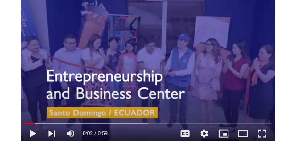 Video still with a line of people cutting a ribbon to open a new center and the words "Entrepreneurship and business center: Santo Domingo, Ecuador"