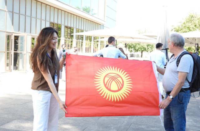 Two people holding flag of the Kyrgyz Republic