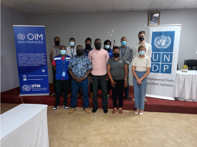 11 people standing next to the IOM and UNDP Mozambique banners