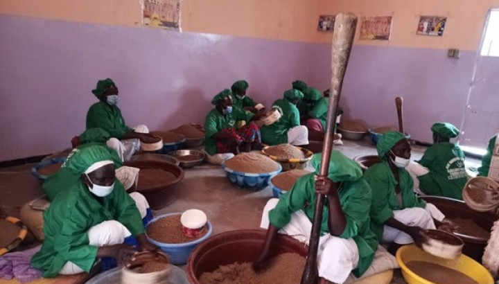 A group of people are working in a food workshop