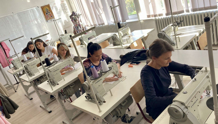 students doing tailoring using sewing machine in a class room